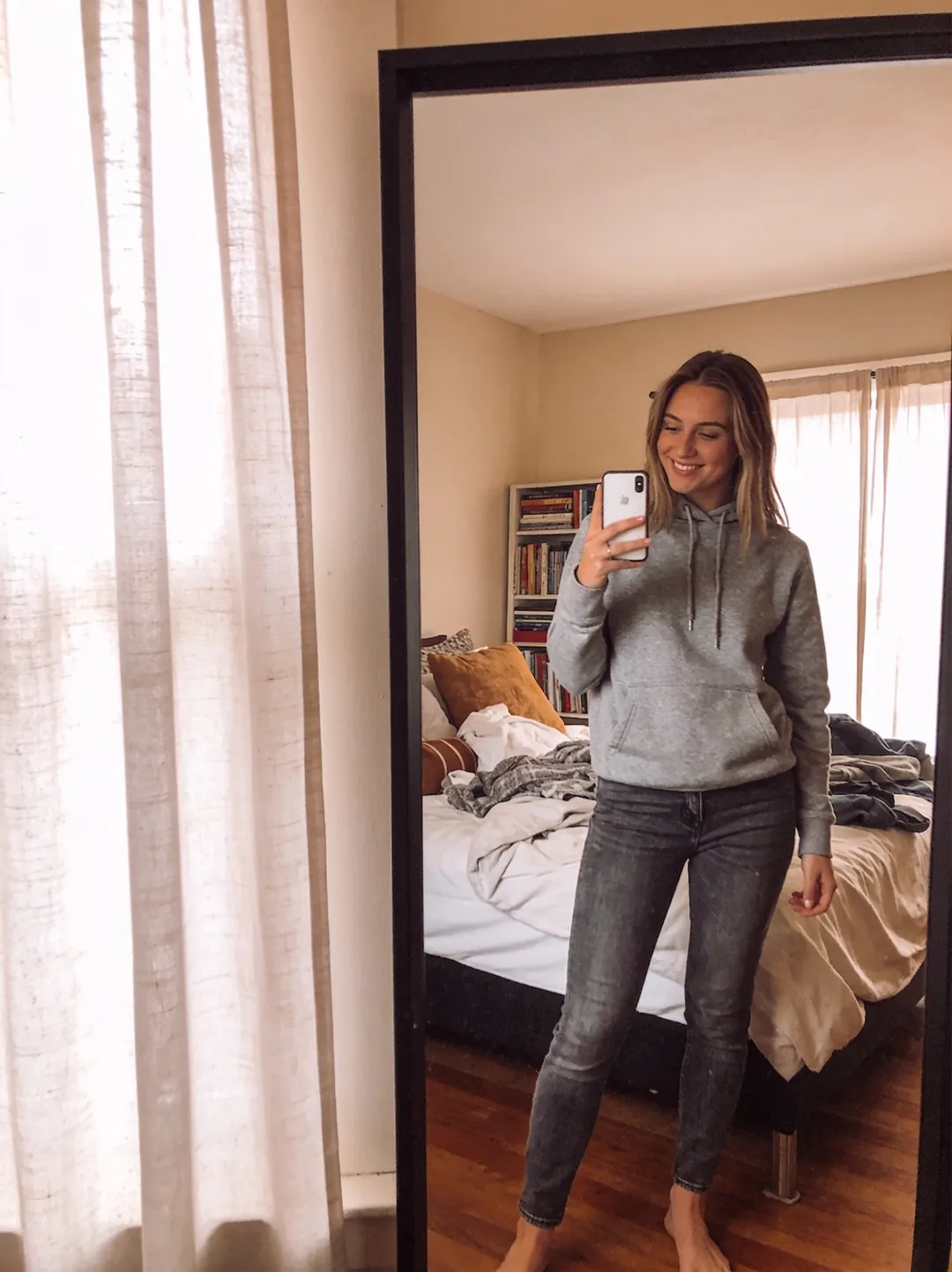 AI photo edit — before: the original mirror selfie in a grey hoodie and jeans